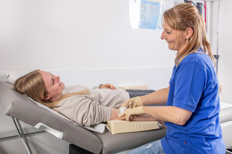Arzthelferin nimmt einer Patientin Blut ab